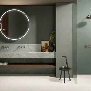 Flora shower mixers by Fantini aligned vertically beneath a round overhead shower