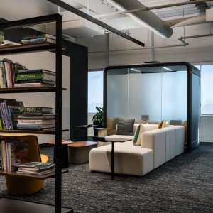 Dark Framery Four pod beside open plan workstations