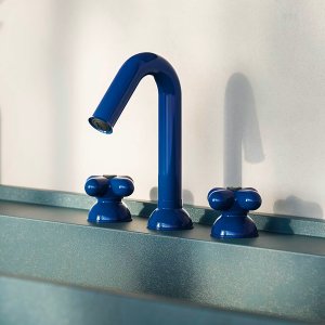 Arched red spout of a Fantini basin mixer photographed in profile