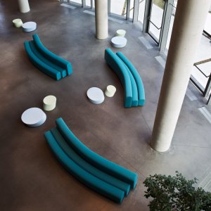Reception waiting area with a closed ring of Osaka seating around a planter