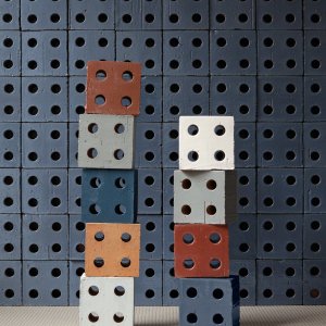 Towers of coloured Bloc blocks against a Bloc Blue wall