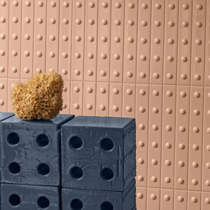 Wall clad with Punto ceramic listels by Mutina, raised-dot texture